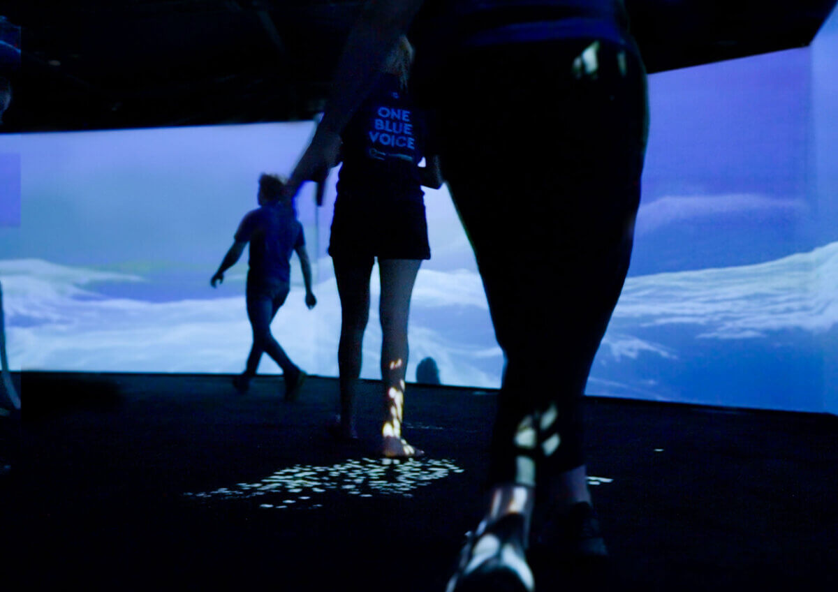 One Blue Voice visitors walking in The Pavilion surrounded by 3D animated ocean immersive experience