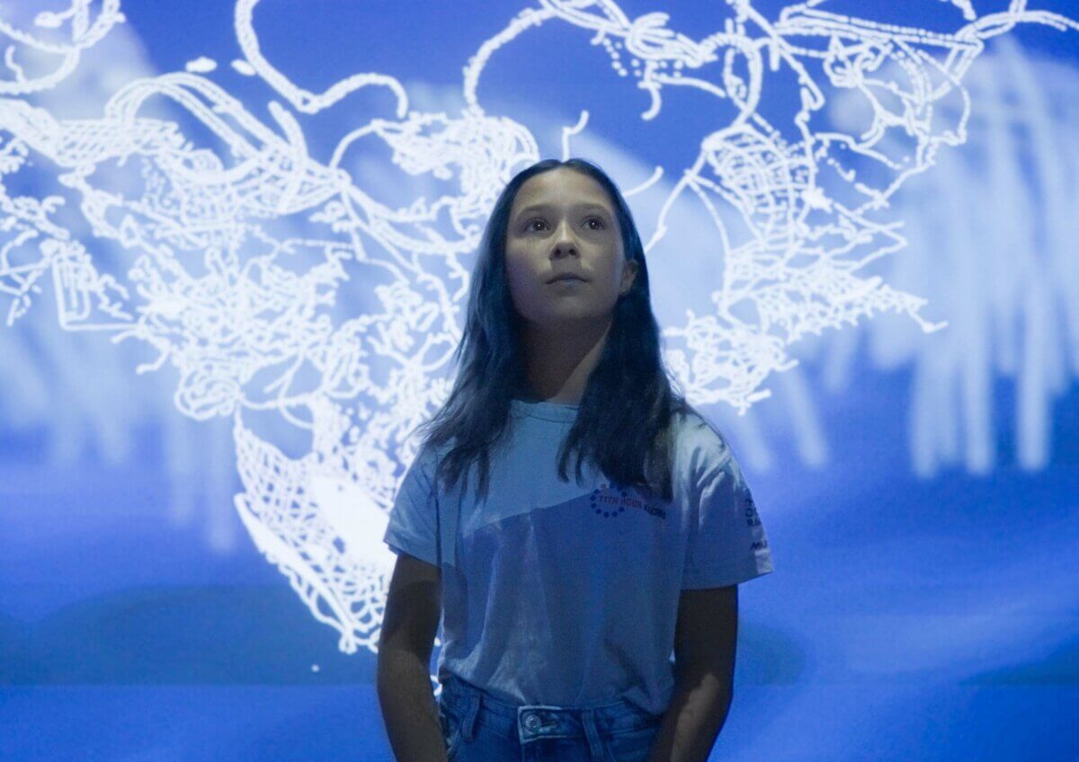 One Blue Voice child looking at 3D animated ocean as sonic soundscape design immersive experience