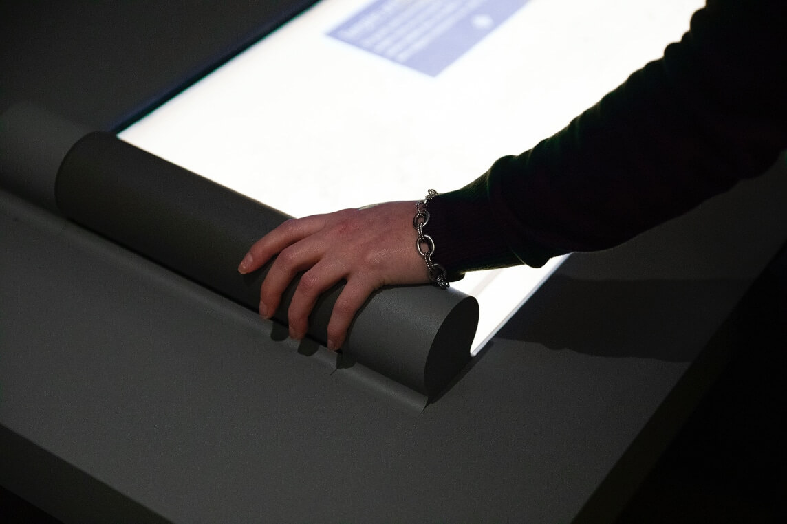 Visitors using Chinese handscroll display Museum learning through interactivity