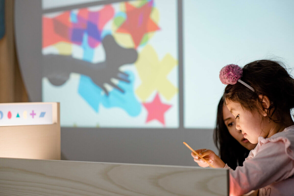 Child using a digital art installation with emerging technology