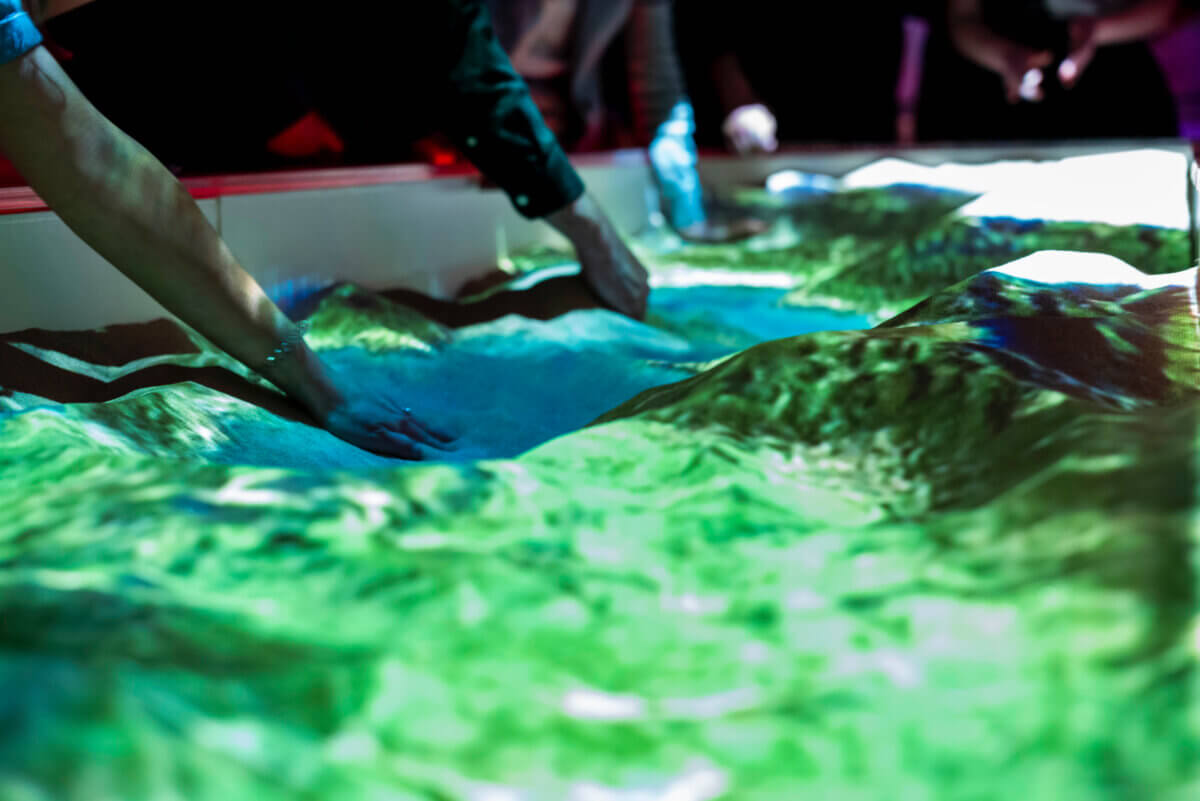 Visitors shaping landscapes with hands in sand